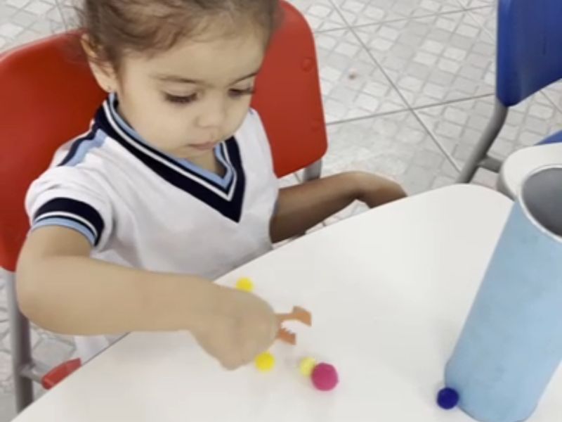 Movimento de Pinça com Pompons Coloridos